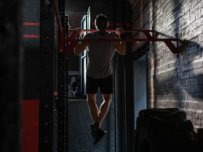 Athletic male hands holding a pull-up bar firmly