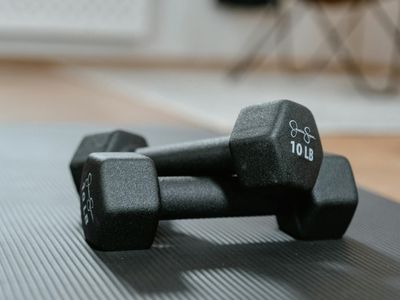 Heavy black dumbbell resting on a gym mat